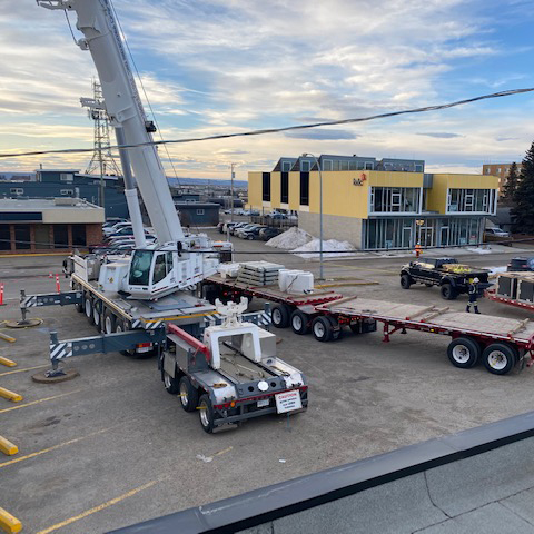 Crane unit lifting air conditioning units on to the roof of an RBC Bank location in Fort St. John